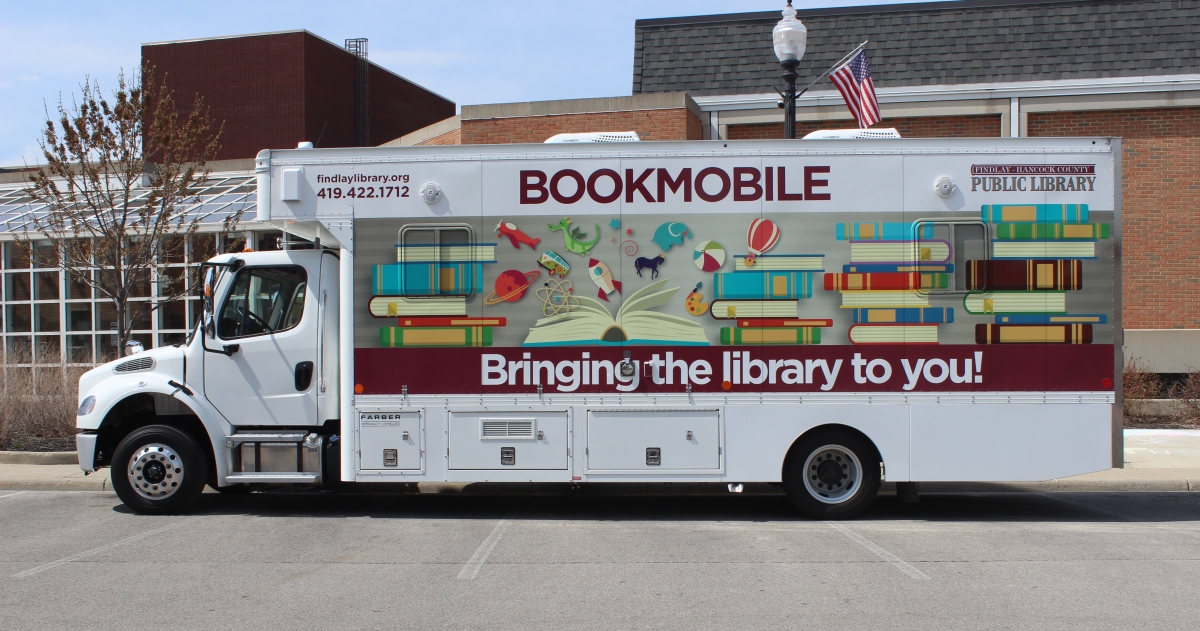 new bookmobile with colorful graphics showing books and various children's toys