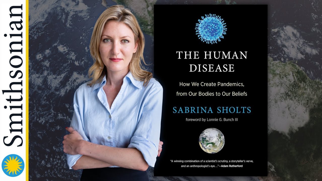 Woman in Blue shirt with arms crossed and black book cover with enlarged blue virus on it